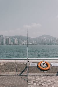gray and black fishing rod beside orange lifebuoy thumbnail