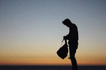 silhouette photo of man holding bag thumbnail