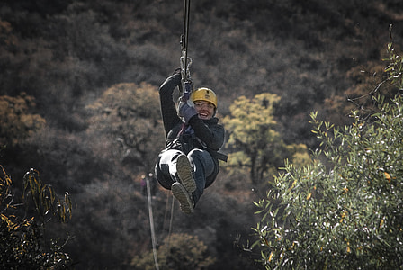 smiling woman riding on zip line at daytime thumbnail