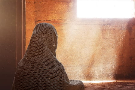 person with headscarf looking in the window wallpaper thumbnail