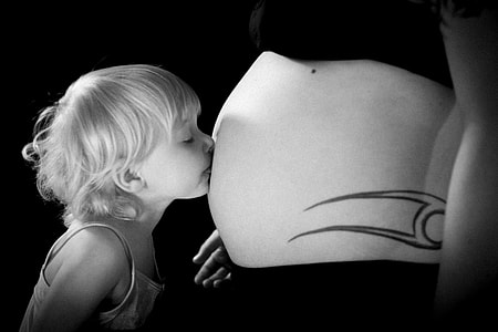grayscale photography of girl kissing on woman's navel thumbnail