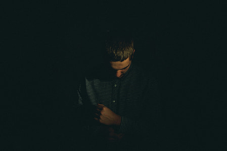 low light photography of man in black button-up shirt thumbnail