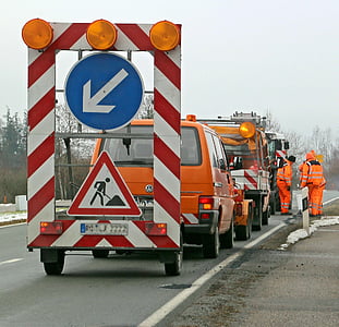 men at work on road near cars thumbnail