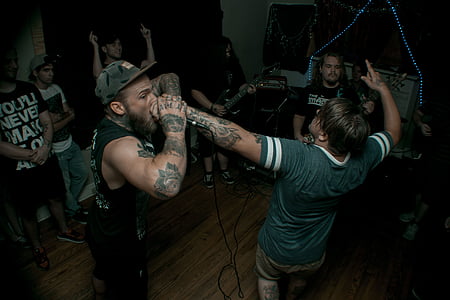 fan screaming on band vocalist microphone on his hand inside room thumbnail