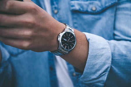 person wearing watch and blue denim shirt thumbnail