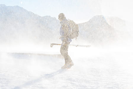 man holding ski poles standing on ground coated with snow thumbnail
