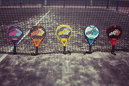 five assorted-colored rackets on mesh net thumbnail