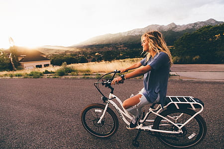 woman riding white bicycle during daytme thumbnail