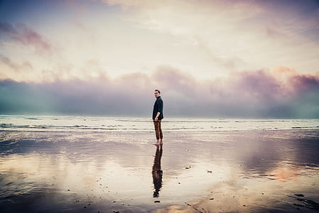person standing on seashore during daytime thumbnail