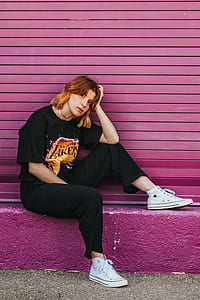 woman sitting while leaning on pink roller shutter thumbnail