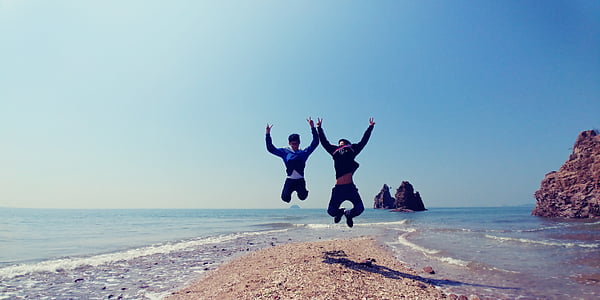 men jumping near body of water thumbnail