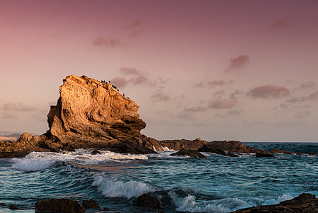 rock formation on body of water during daytime thumbnail