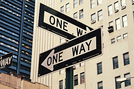 white-and-black One Way road signs near building thumbnail