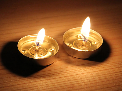 two lighted tealight candles on brown surface thumbnail
