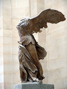 angel statue near white wall thumbnail