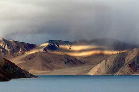 aerial photography of mountain near body of water thumbnail