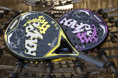 two tennis rackets with head covers placed on black net thumbnail
