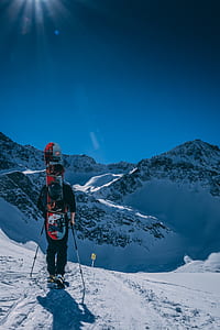 man holding red and gray snowboard thumbnail
