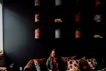 woman sitting on sofa between throw pillows thumbnail