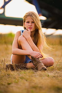 girl sits on green grass field thumbnail
