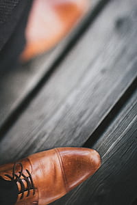 pair of brown leather shoes on gray wooden surface thumbnail