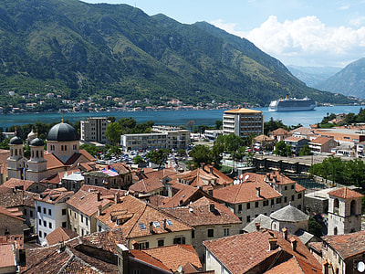aerial photography of houses near body of water and mountains during daytime thumbnail