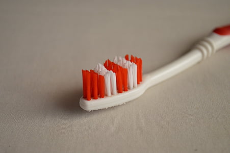 white and red toothbrush on white surface thumbnail
