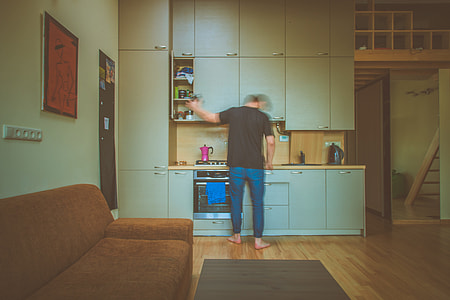 photo of man in front of kitchen cabinet opening one door of cabinet thumbnail