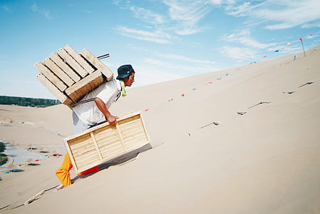 man carrying beige wooden frames thumbnail