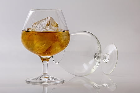 clear wine glass with half-filled with liquor and ice thumbnail