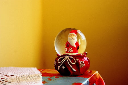 red Santa Claus water globe on top of red and blue tablecloth thumbnail