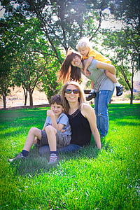 woman sitting on green grass surrounded by trees thumbnail