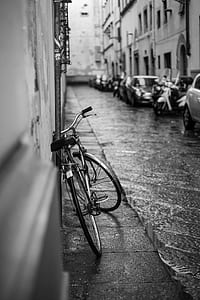 grayscale photo of a city bicycle leaning on a wall thumbnail