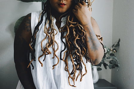 photography of person wearing white sleeveless top behind white wall thumbnail