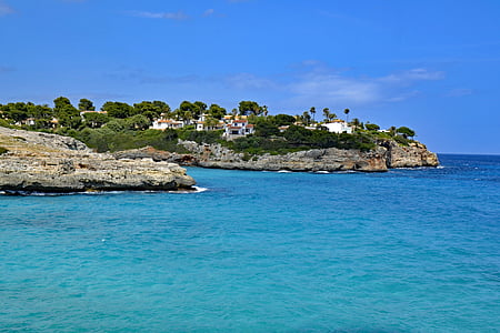 houses on cliff beside body of water thumbnail