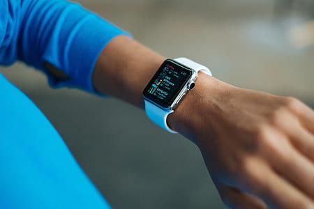 person using silver aluminum Apple Watch with white Sport Band photography thumbnail