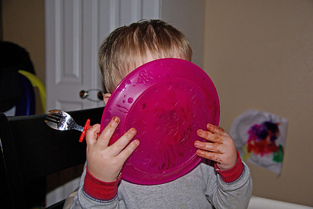 toddler holding pink plate thumbnail