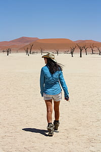 woman wearing blue long-sleeved top walking across desert thumbnail