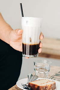 person holding filled drinking glass with liquid thumbnail