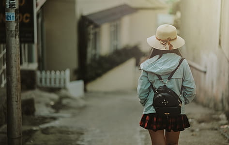 Girl in Blue Jacket and Black Leather Knapsack Walking on Street thumbnail