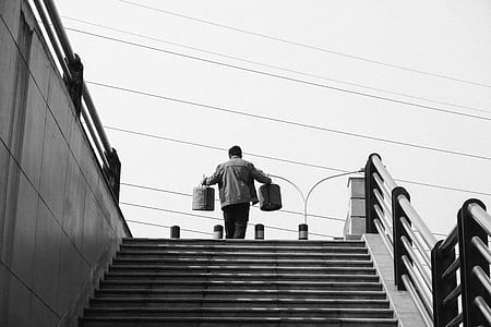 man carrying pails on stairs at daytime thumbnail