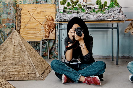 woman holding black DSLR camera thumbnail
