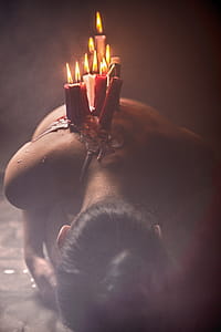 Lit Red and White Candle Lot on Person's Back thumbnail