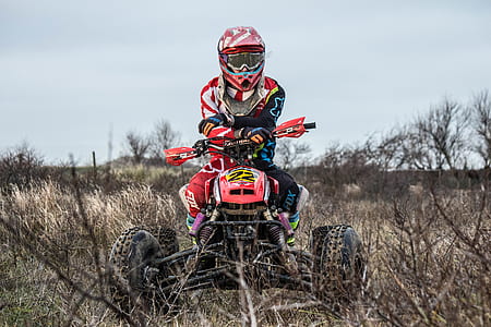 man riding on ATV near trees thumbnail