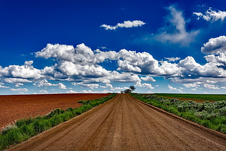 brown rocky road under blue and white cloudy sky thumbnail