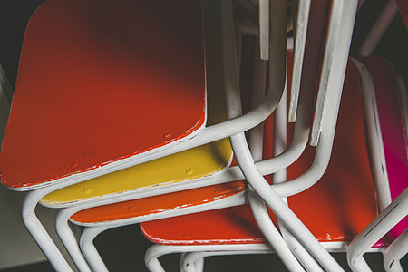 close photo of pile of metal-framed chairs thumbnail