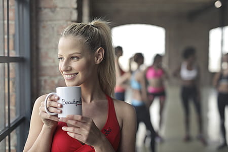 smiling woman holding white mug thumbnail