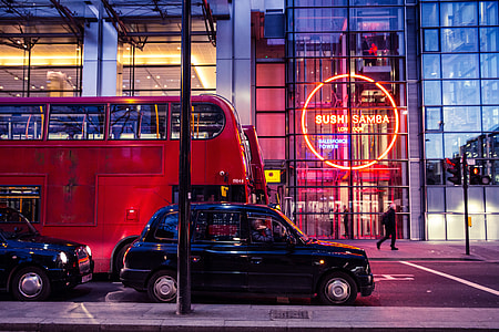 Red buses and black taxis sit on a busy London street thumbnail