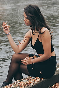 woman sitting near body of water thumbnail