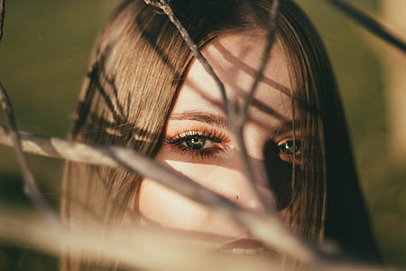 woman looking through tree branches thumbnail
